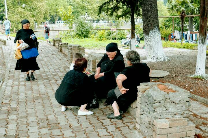 Frauen tauschen sich aus, traditionell in Schwarz gekleidet