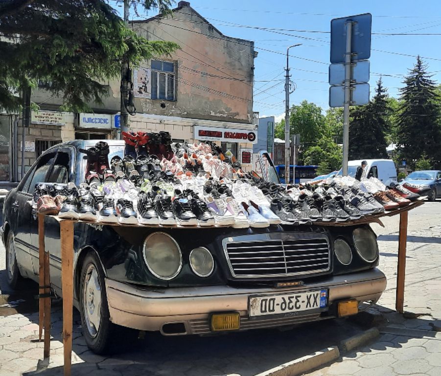 Schuhe werden in der Strasse verkauft, der Stand sieht aus wie ein Auto von James Bond
